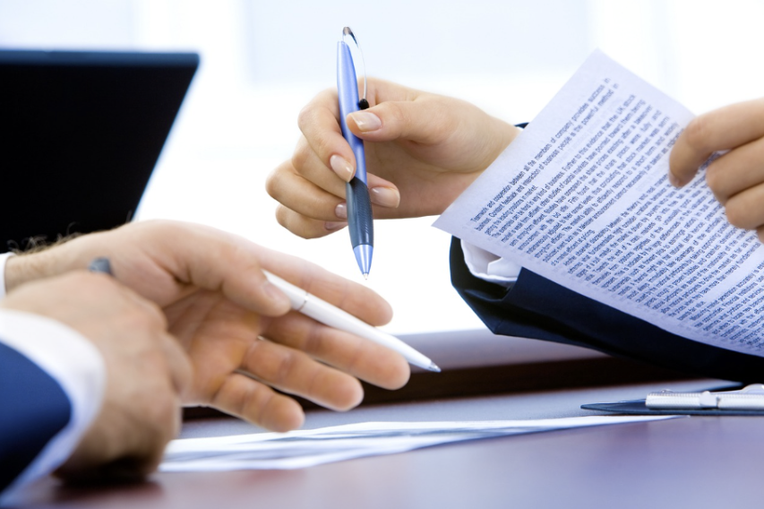 Close-up of hands holding documents during a meeting